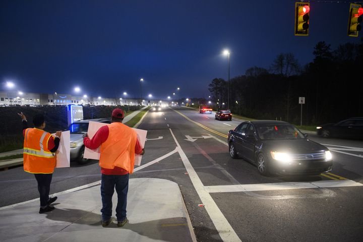 Union activists stand in front of cars at an intersection outside the Amazon warehouse in Bessemer, Alabama, March 27, 2021 (PATRICK T. FALLON / AFP)