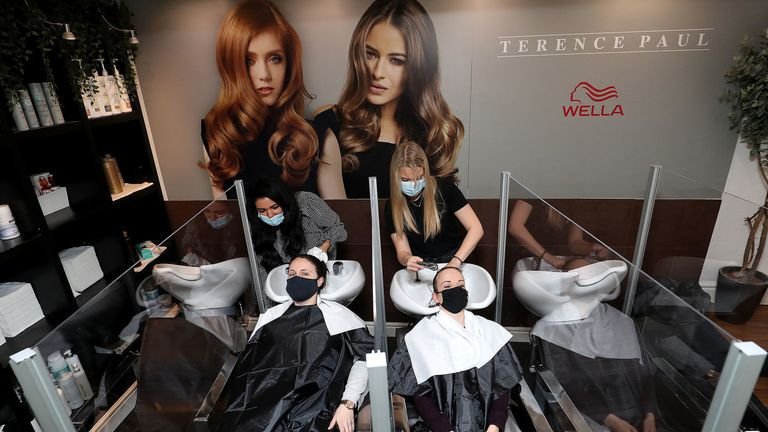 Louise Boothby (L) and Chloe Travis get their hair washed in a salon in Knutsford, Cheshire
