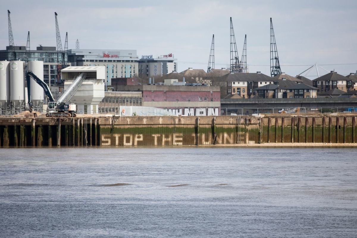 Campaigners hosed down the slogan to stop the tunnel on the Thames quay near the proposed site of the tunnels