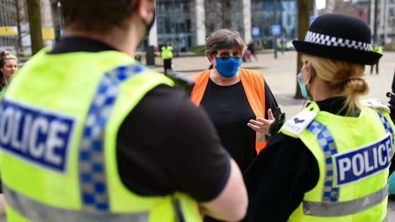Police talk to NHS worker Karen Reissmann after breaking up protest in Manchester