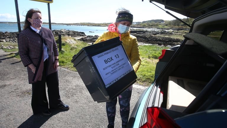 Shona Barton of the Argyll and Bute Council Director's Office team hands over equipment to President Morven Beagan (right) for use at a polling station on Gigha Island