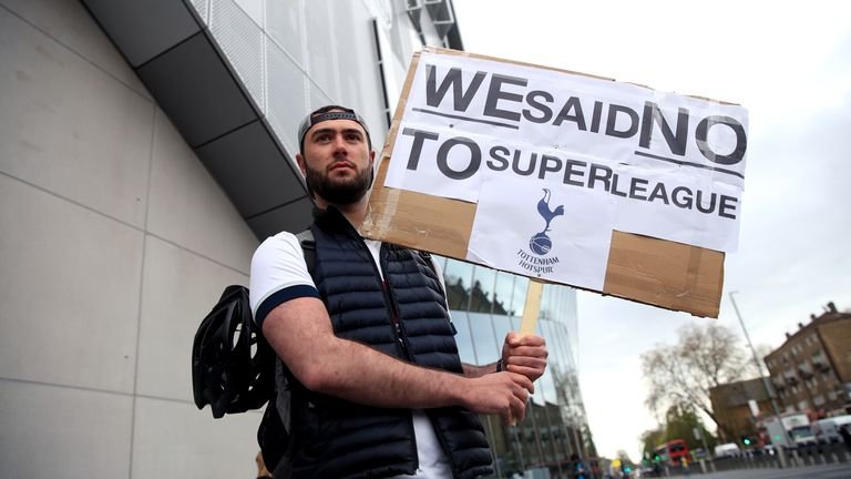 A Spurs fan holds a sign outside their north London stadium