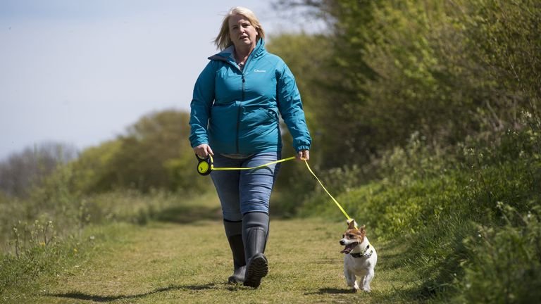 Under embargo at 2:30 p.m. Tuesday, May 11 An actress playing the role of the PCSO Julia James walks her dog Jack Russell Toby, who was found at the scene, as they reconstruct the route taken by Julia and Toby in the fields behind her house in the hamlet of Snowdown, near Aylesham, Kent.  Photo date: Tuesday, May 11, 2021.