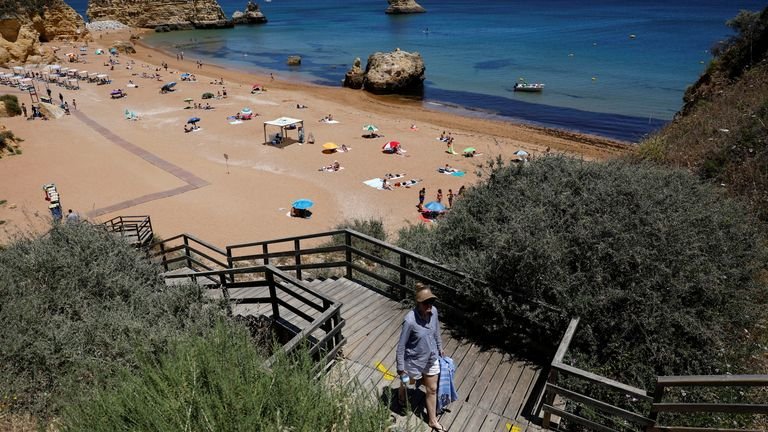 A person leaves Dona Ana beach in Lagos, Portugal