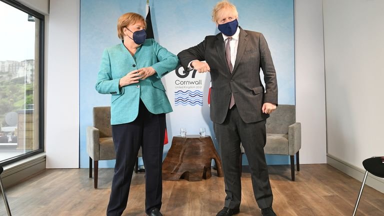 British Prime Minister Boris Johnson and German Chancellor Angela Merkel hit each other on their elbows as they attend a bilateral meeting at the G7 summit in Carbis Bay, Cornwall, Britain on June 12, 2021. Stefan Rousseau / Pool via REUTERS