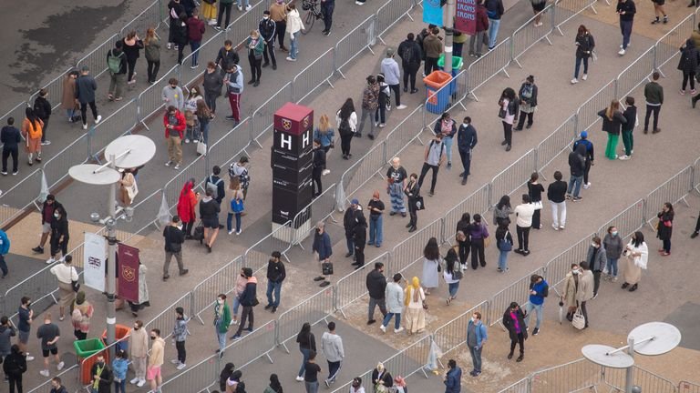 People line up outside an NHS vaccination clinic at London's West Ham Stadium in Stratford, east London.  The NHS is prepared for high demand as anyone in England over the age of 18 can now reserve a vaccine against Covid-19.  Picture date: Saturday June 19, 2021.
