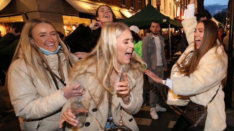 People celebrate being out for the evening in Old Compton Street, Soho, in central London, where streets have been closed to traffic to create outdoor seating areas for bars and restaurants to reopen 04 / 12/2021