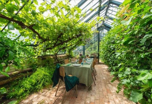 L'Argus: The house has an amazing dining table in a greenhouse