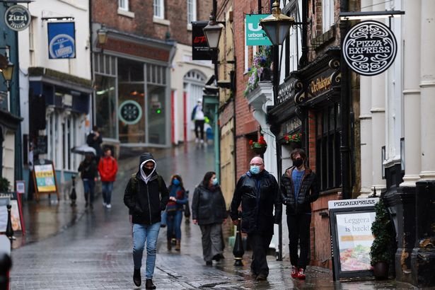 People wear masks and face coverings while shopping in Durham city center