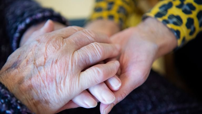 Hand holding in the care home.  Photo: AP