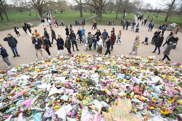 Times Series: People viewing floral tributes took to the bandstand at Clapham Common, London, for Sarah Everard