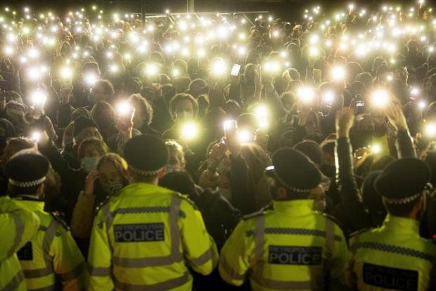 Times Series: People in the crowd light their phone torches as they gather at Clapham Common, London, for a vigil for Sarah Everard