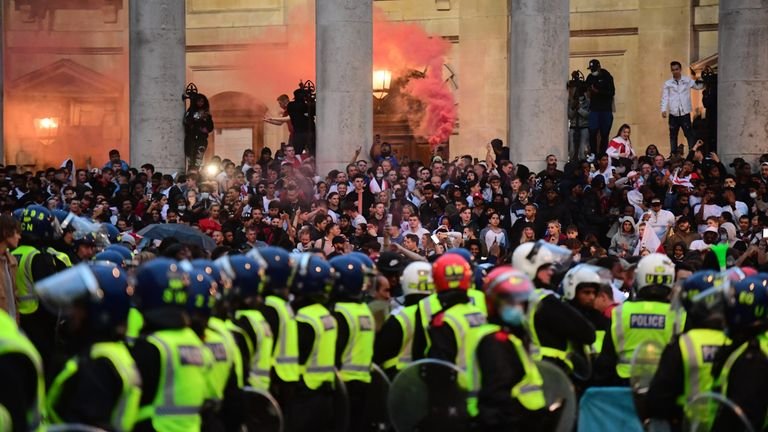 Police officers watch English fans launching flares from the steps of St Martin-In-The-Fields Church in Trafalgar Square, London, during the UEFA Euro 2020 final between Italy and England.  Picture date: Sunday July 11, 2021.