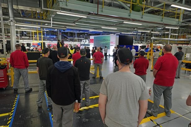 Workers listen to Nissan COO Ashwani Gupta announce the Japanese auto giant to build a new electric model in Sunderland