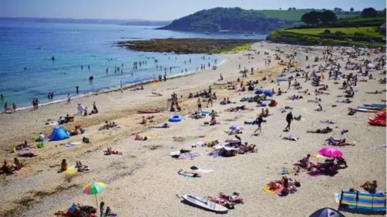 People soak up the sun on Gyllyngvase Beach near Falmouth in Cornwall on Sunday