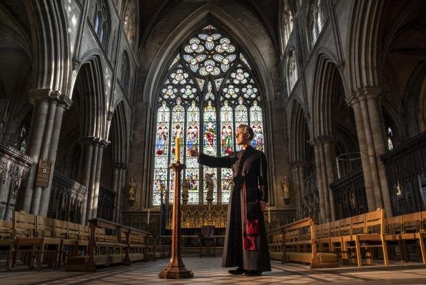 Times Series: The Very Reverend John Dobson Dean of Ripon lights a candle to mark the second anniversary of the first national coronavirus lockdown at Ripon Cathedral in North Yorkshire ahead of the National Day of Reflection on Wednesday (PA)