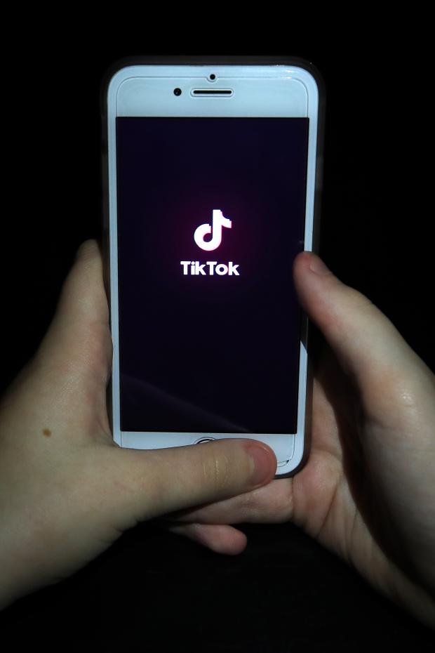 Times Series: A person with TikTok open on their phone.  Credit: PA