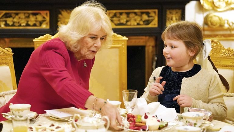 Queen Camilla takes tea with seven-year-old Olivia Taylor from Sidcup at Windsor Castle