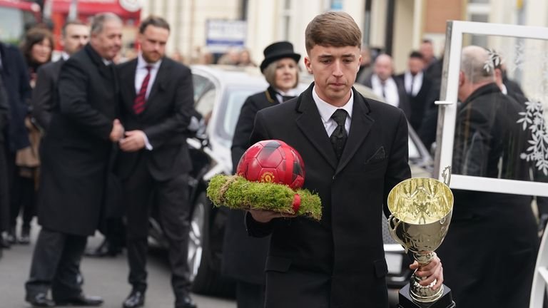 A football and trophy being carried into the church 